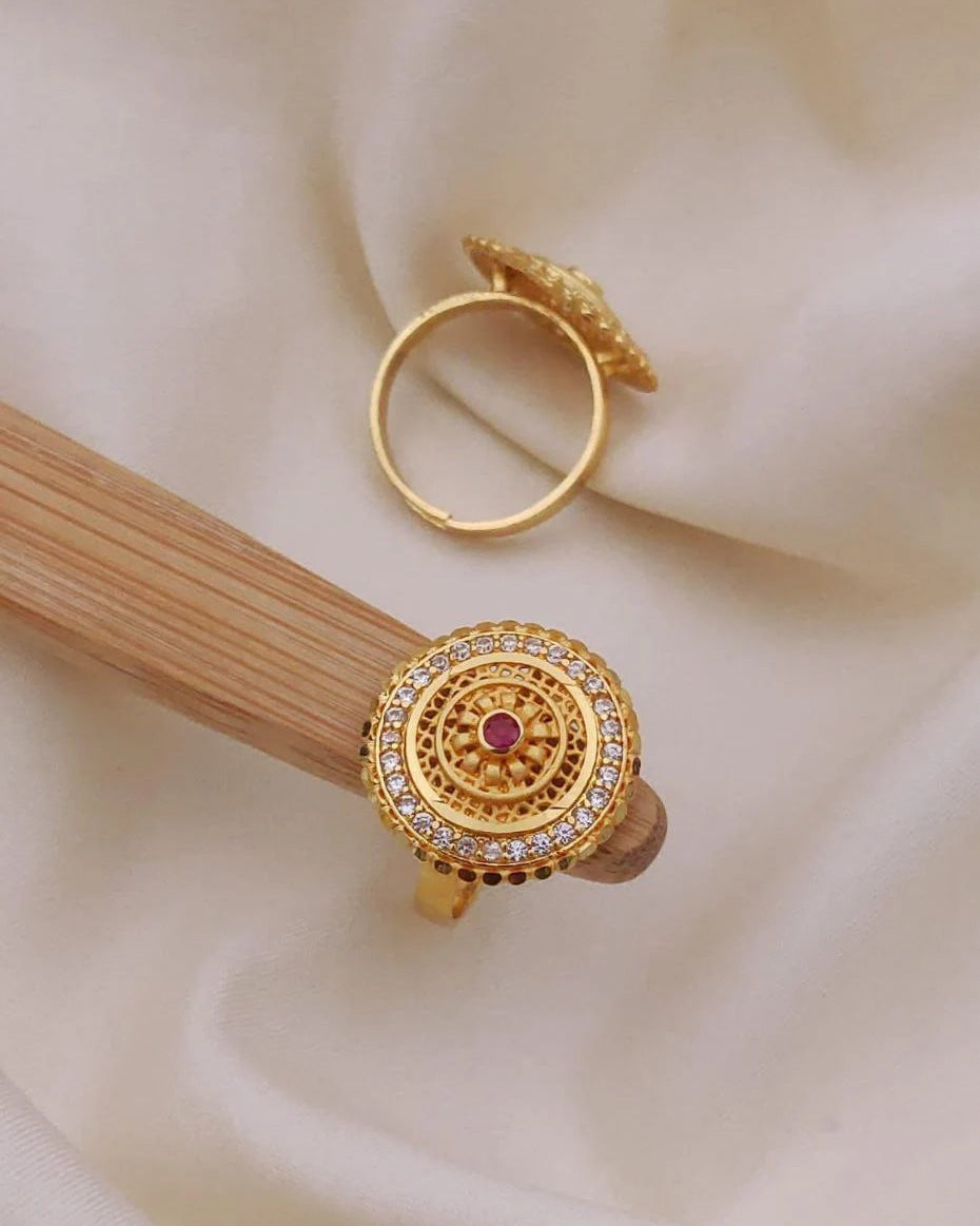 Gold ring with gemstone on a beige fabric background