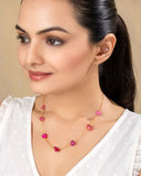 Woman wearing a necklace with pink beads against a neutral background