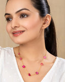 Woman wearing a pink beaded necklace against a beige background