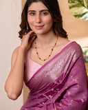 Woman wearing a pink saree with a subtle background