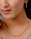 Woman wearing a gold necklace with a blurred background