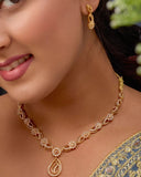Woman wearing a gold necklace and earrings with a blue saree