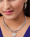 Close-up of a woman wearing a diamond necklace and earrings on a blue saree.