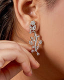 Close-up of a person wearing a silver floral earring.