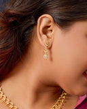 Close-up of a person wearing gold earrings and a necklace.