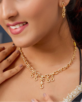 Woman wearing a gold necklace with a blurred background