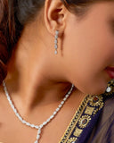 Close-up of a woman wearing a necklace and earrings with a blurred background