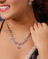 Woman wearing a diamond necklace and earrings, close-up on face and neck.