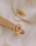 Gold ring with gemstone on a wooden stick against a soft beige background