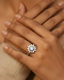 Hand wearing a diamond ring with a blurred background