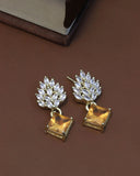 Gold earrings with clear gemstones on a brown surface