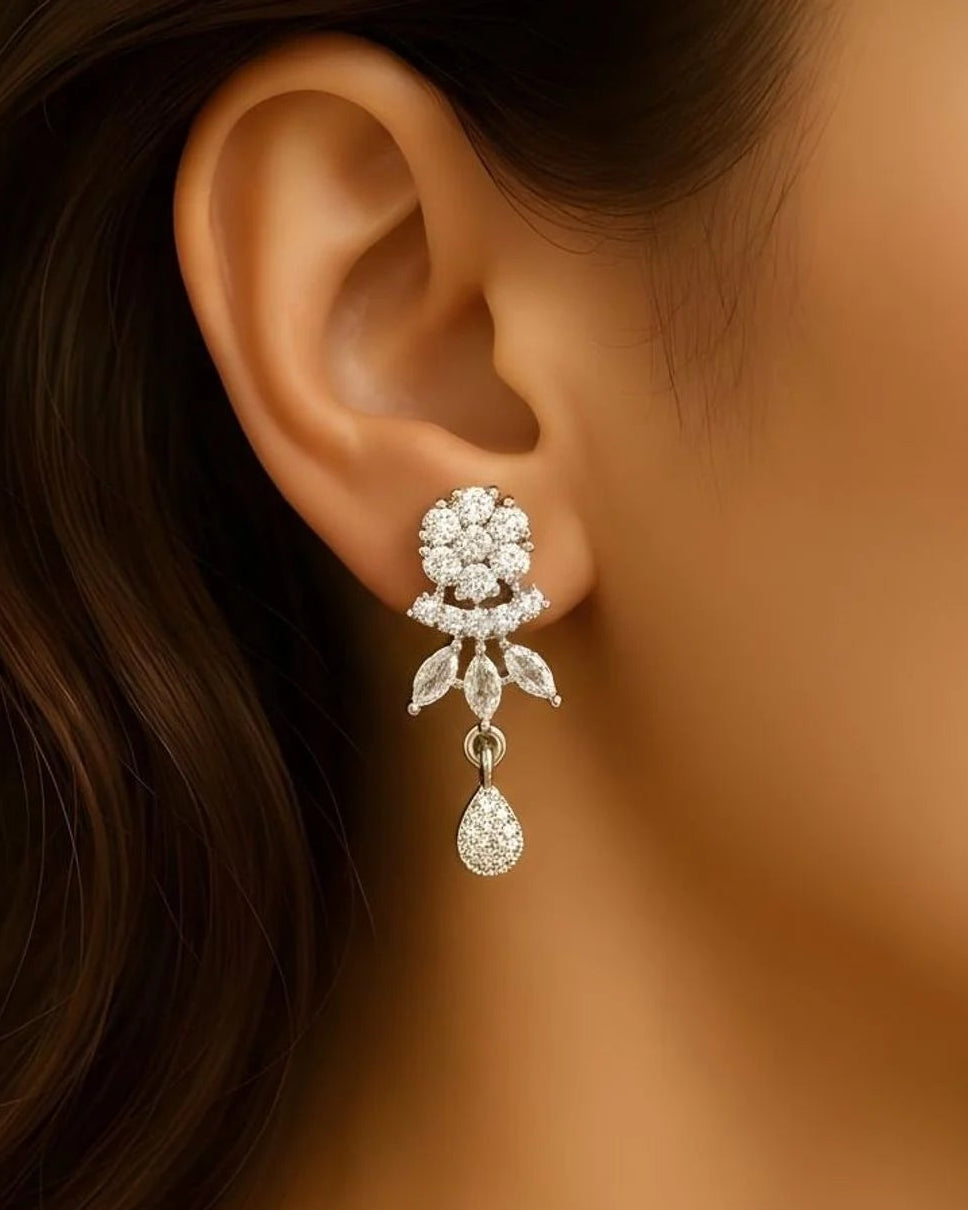 Close-up of an ear wearing a sparkling diamond earring with a dark hair background