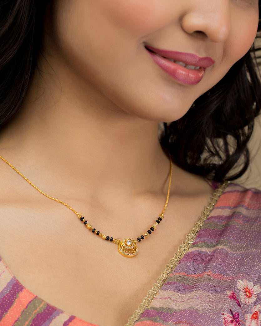 Woman wearing a gold necklace with a floral background