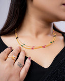 Woman wearing a yellow beaded necklace with a black background