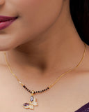 Close-up of a woman wearing a gold necklace with a pendant.