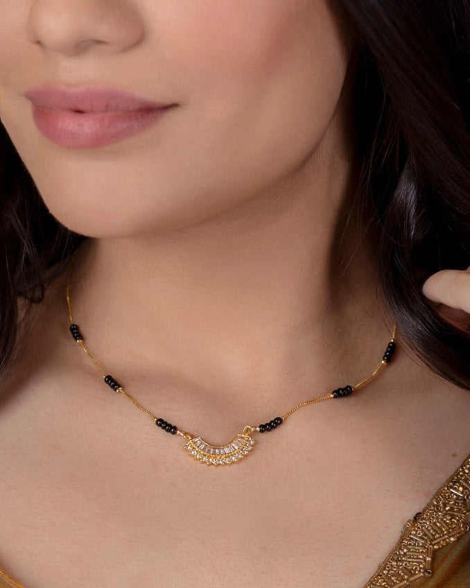 Woman wearing a gold necklace with a plain background