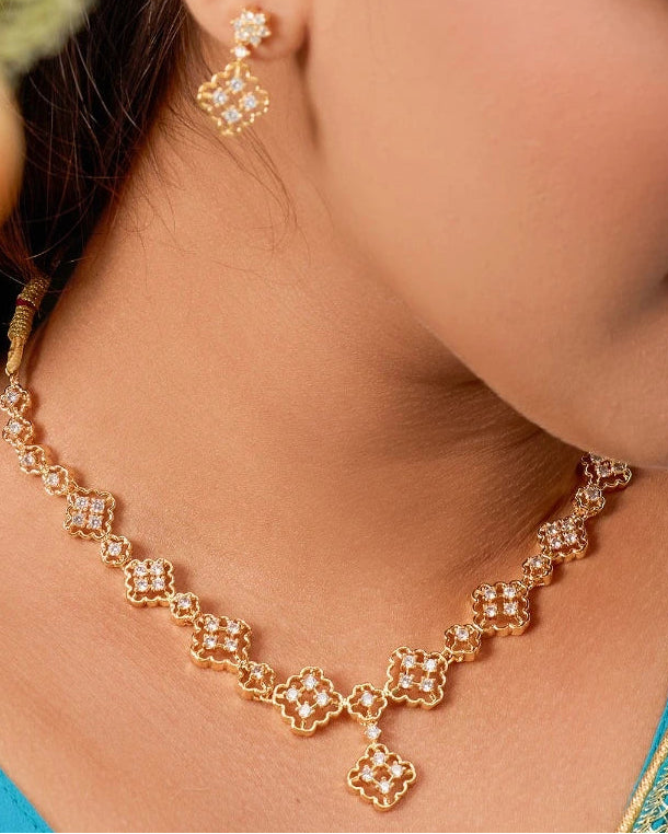 Woman wearing a gold necklace and earrings, with a close-up of the jewelry.