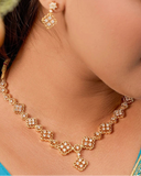 Woman wearing a gold necklace and earrings, with a close-up of the jewelry.