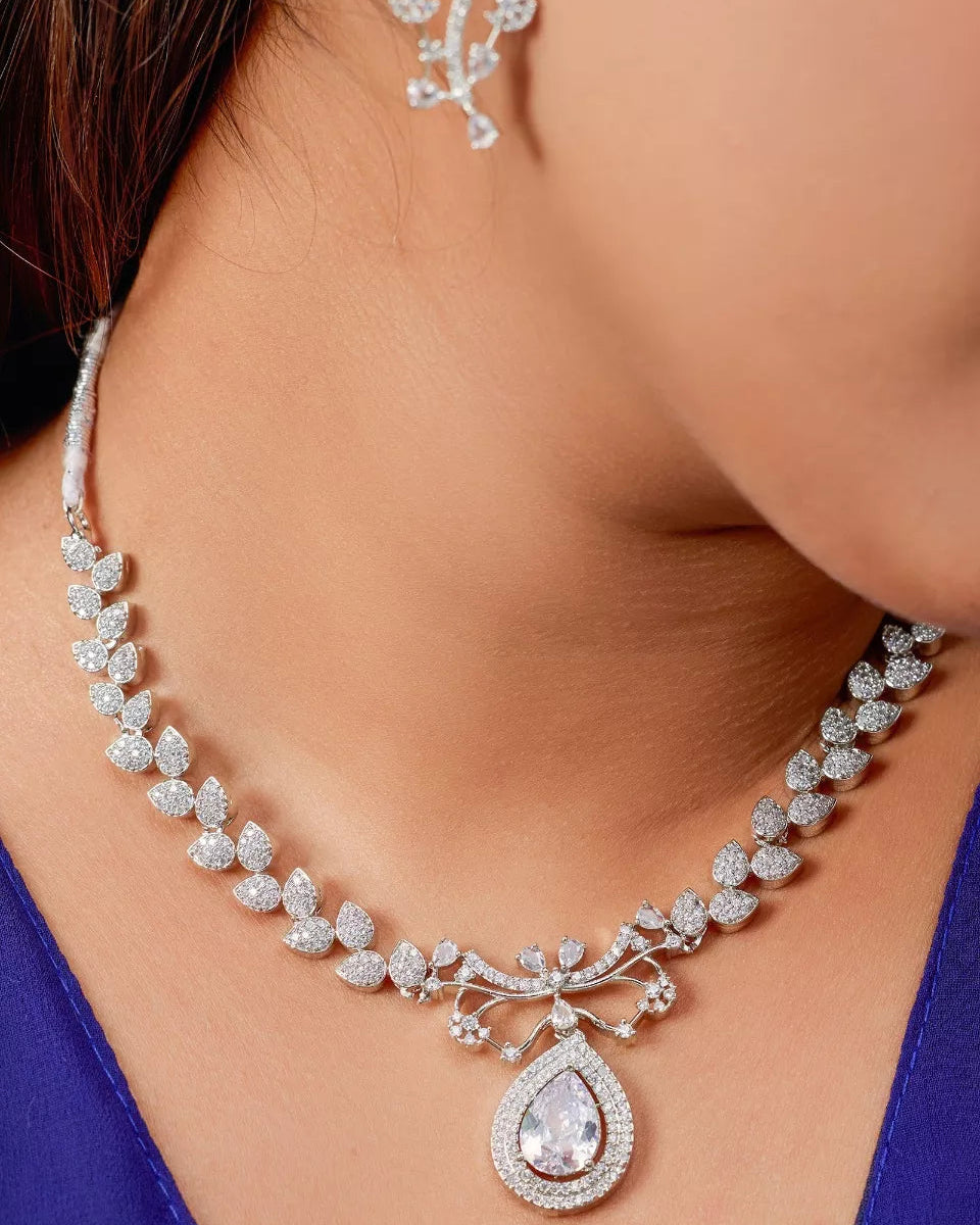 Diamond necklace and earrings on a model wearing a blue dress