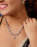 Woman wearing a diamond necklace and earrings, close-up on face and neck.