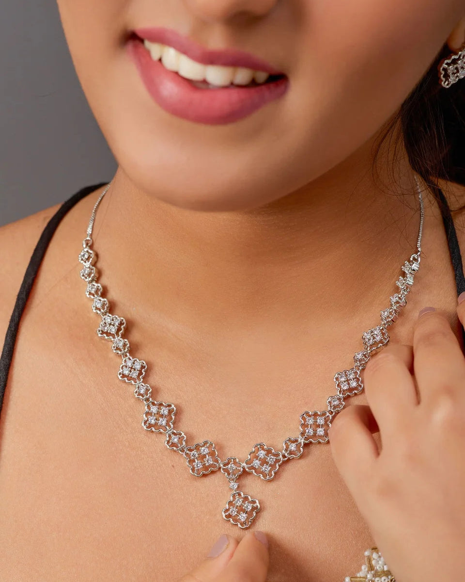Close-up of a woman wearing a diamond necklace and earrings.