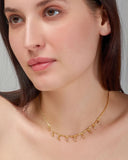 Woman wearing a gold necklace with a plain background