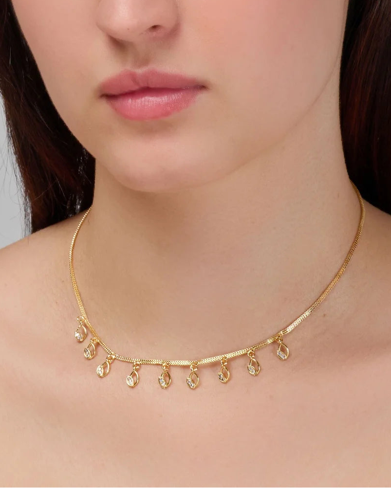 Woman wearing a gold necklace with a plain background