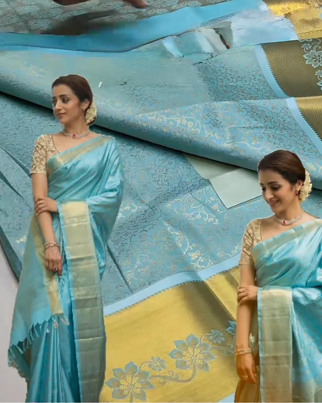 two women wearing light blue sarees with yellow borders, standing next to a fabric display.