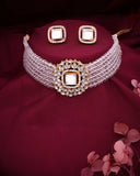 Jewelry set with a choker and earrings on a maroon fabric background
