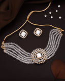 Jewelry set with necklace, earrings, and decorative stones on a dark surface