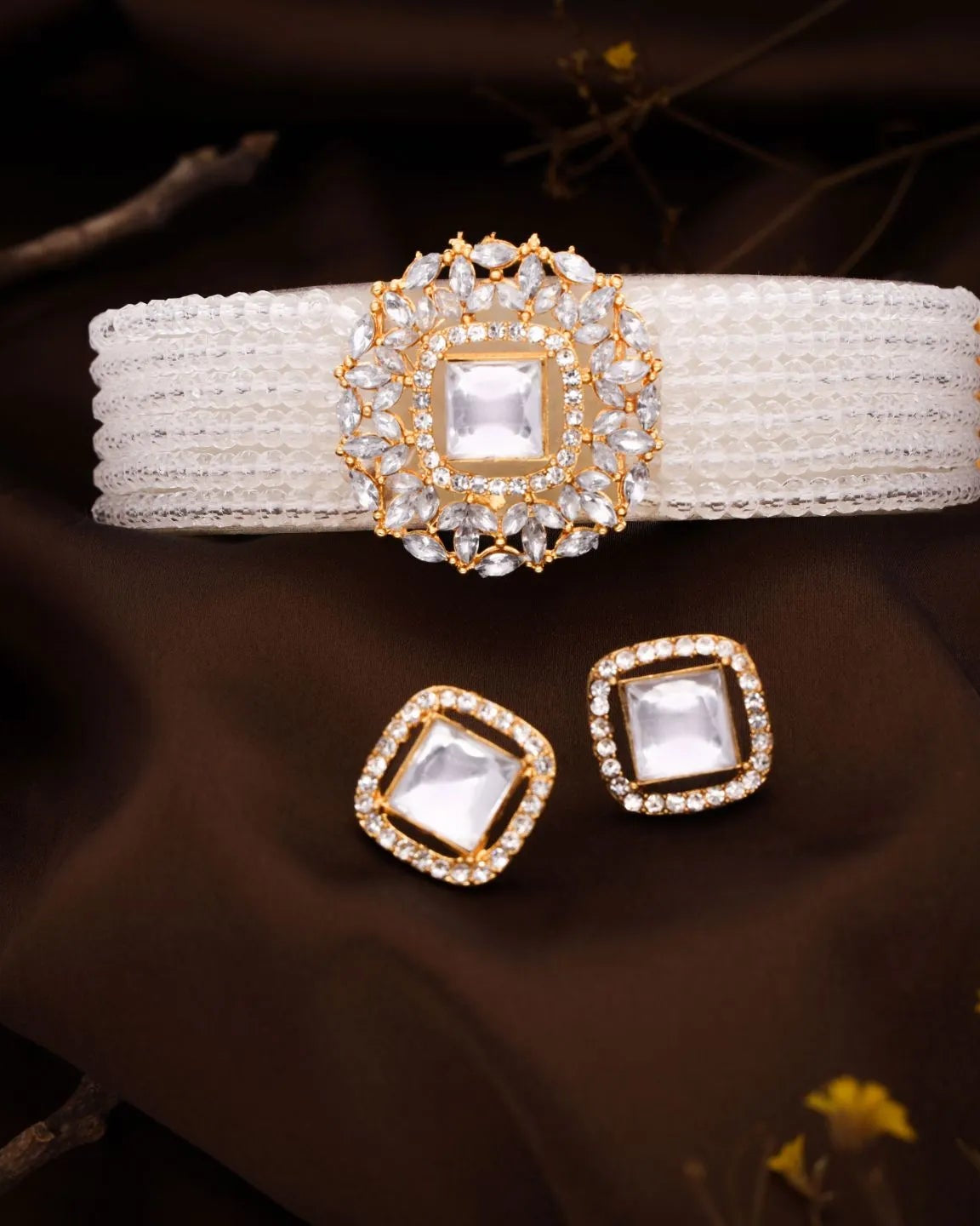 Set of decorative headband and earrings with gold and crystal details on a dark background